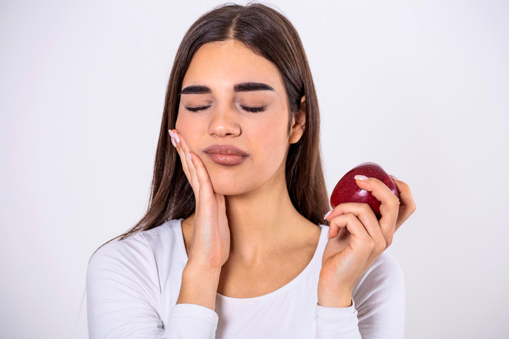 995 sensitive teeth young woman having tooth pain eating apple standing white studio background woman who feels toothpain because sensitive teeth 174387259